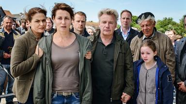 Eine betroffen schauende Menschengruppe