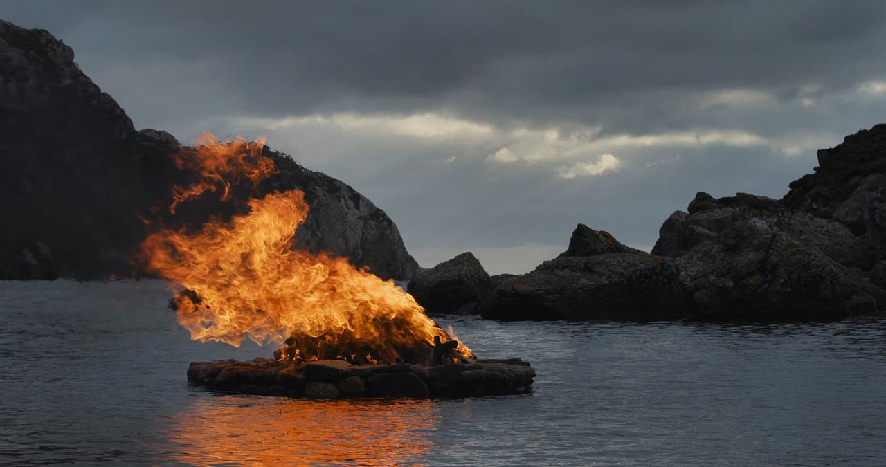 Große Feuerstelle vor Meereslandschaft.