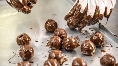 Handschuhe legen frisch umhüllte Trüffel ab