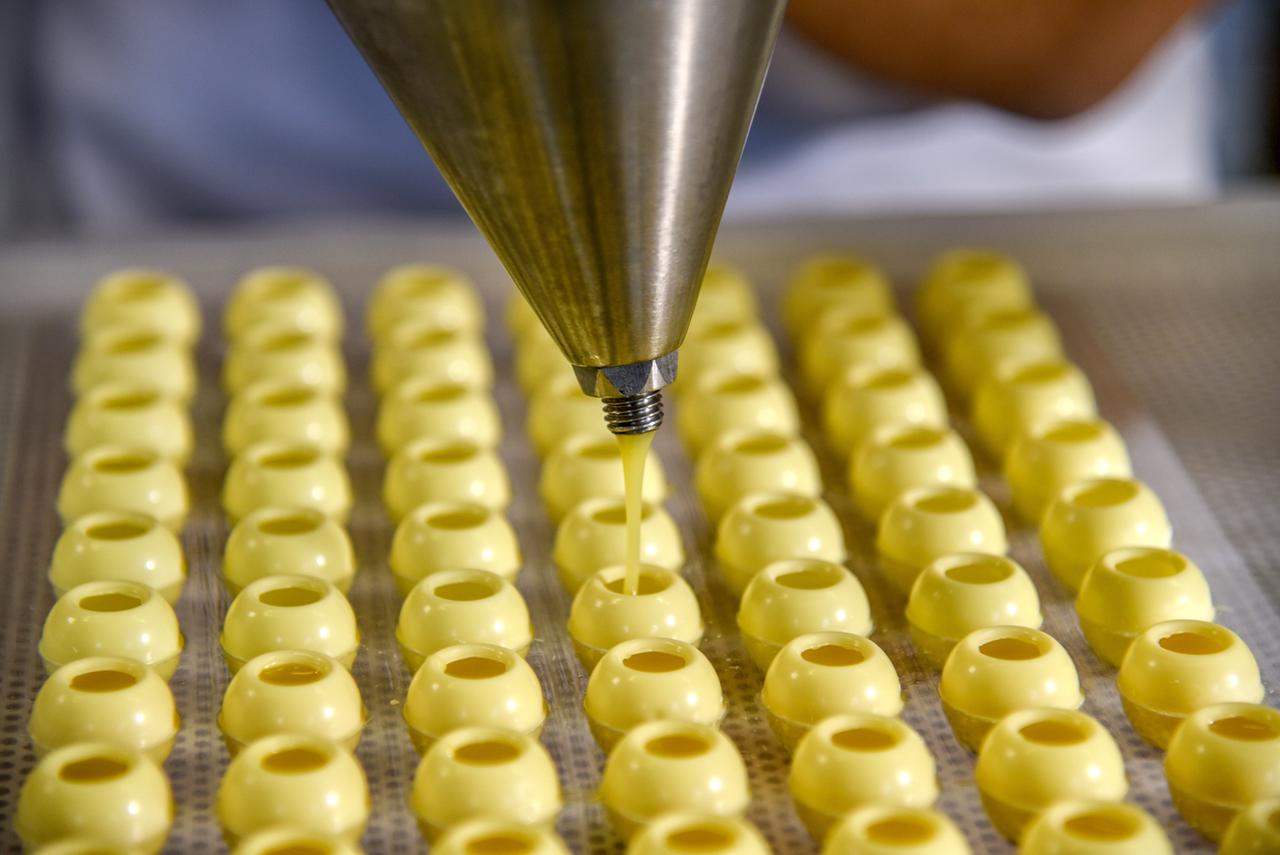 Pralinenhüllen werden mit Creme befüllt