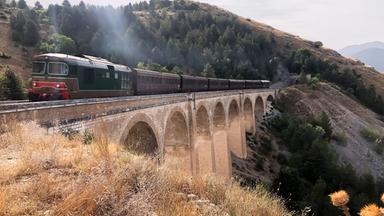Eine Eisenbahn fährt über eine Brücke.