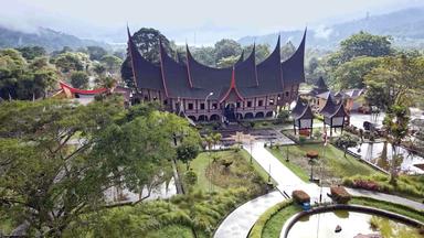 Großes Gebäude mit hochgezogenen Dachgiebeln in einem Park