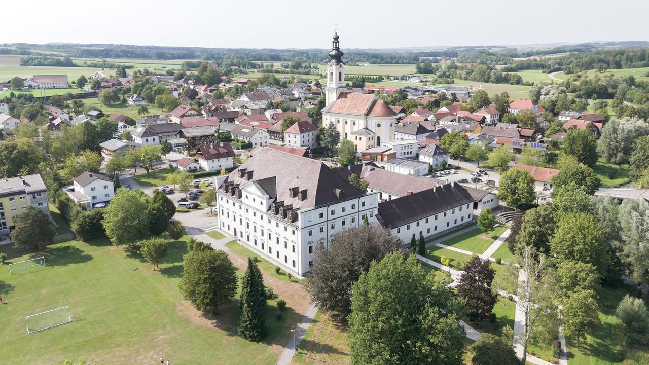 Luftaufnahme von Schloss Zell an der Pram, einem barocken Jagdschloss im Bezirk Schärding, umgeben von gepflegten Gärten und einem kleinen Dorf.