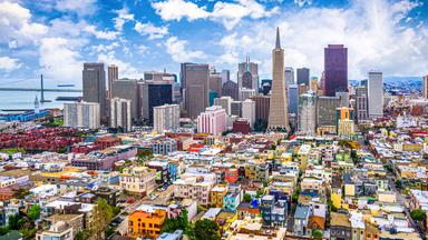 Blick auf Wolkenkratzer, davor viele bunte kleinere Häuser