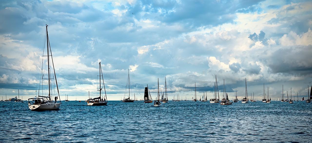 Zahlreiche Segelboote auf dem Wasser unter einem bewölkten Himmel bei der Barcolana-Regatta.