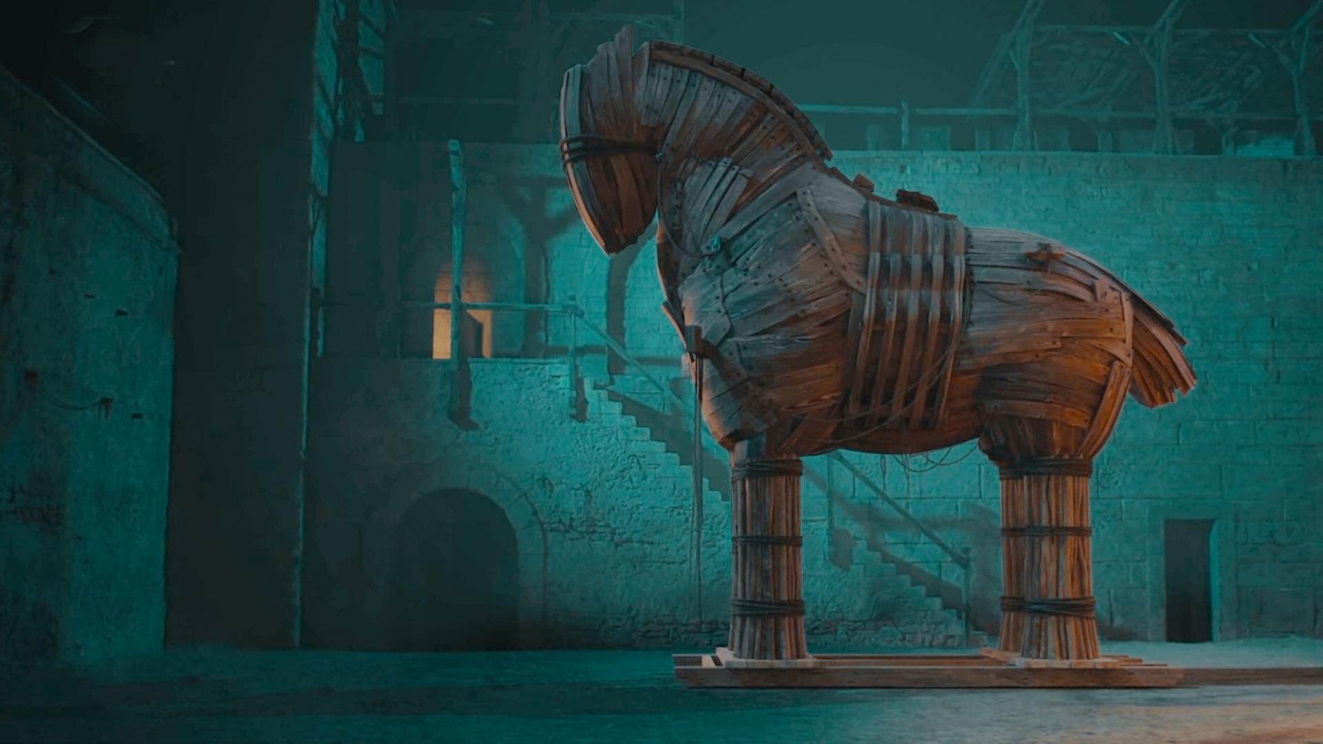 In der Bildmitte der Nachbau des Trojanischen Pferds, rechts im Bild Darsteller des Odysseus mit Bart. In der linken Bildhälfte ein CGI einer Stadtmauer und davor kämpfende Darsteller.