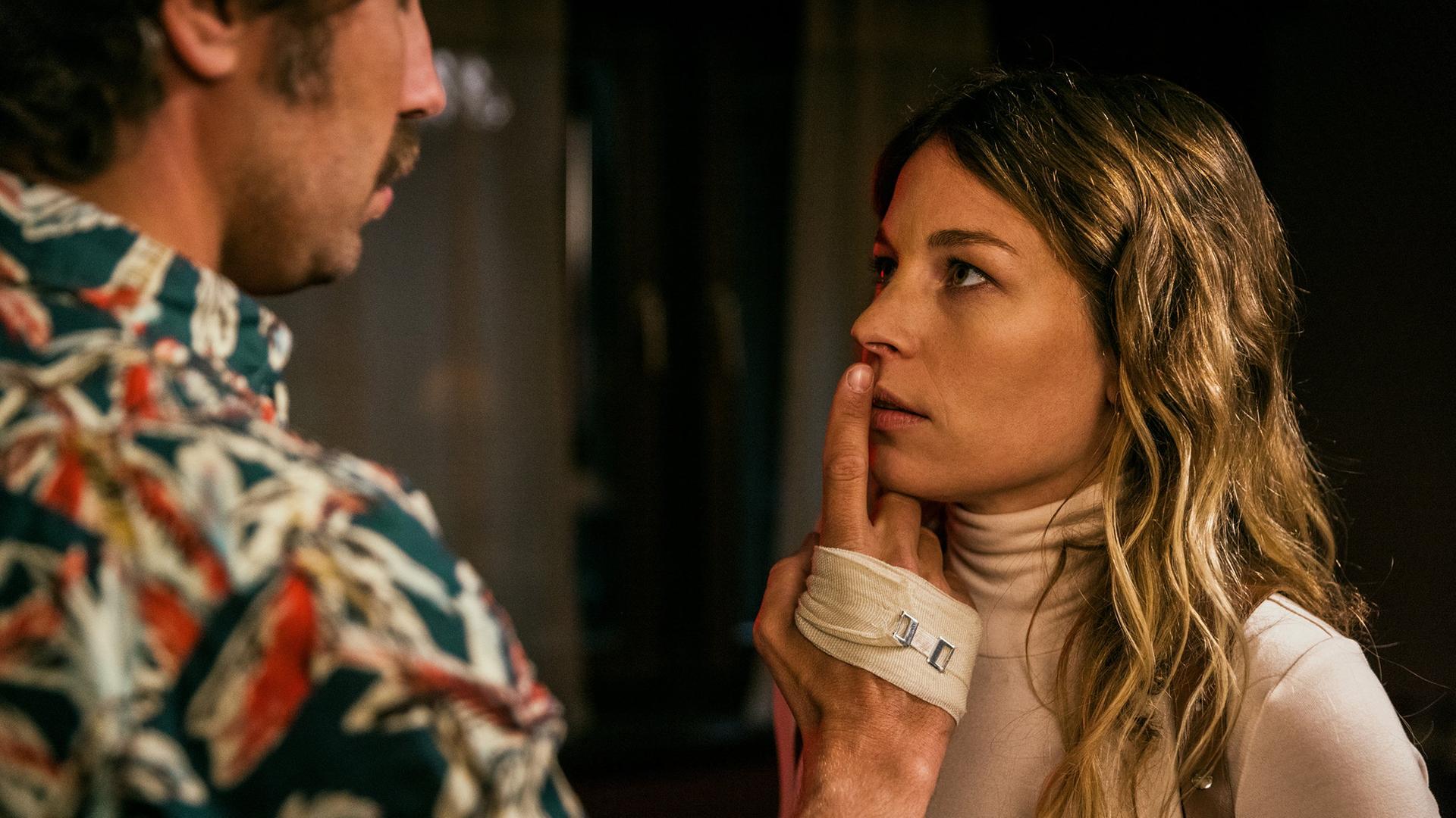 David Constantin als Bax legt Anna Rossinelli als Annette den Finger auf die Lippen; sie stehen nah beieinander und blicken sich intensiv an.