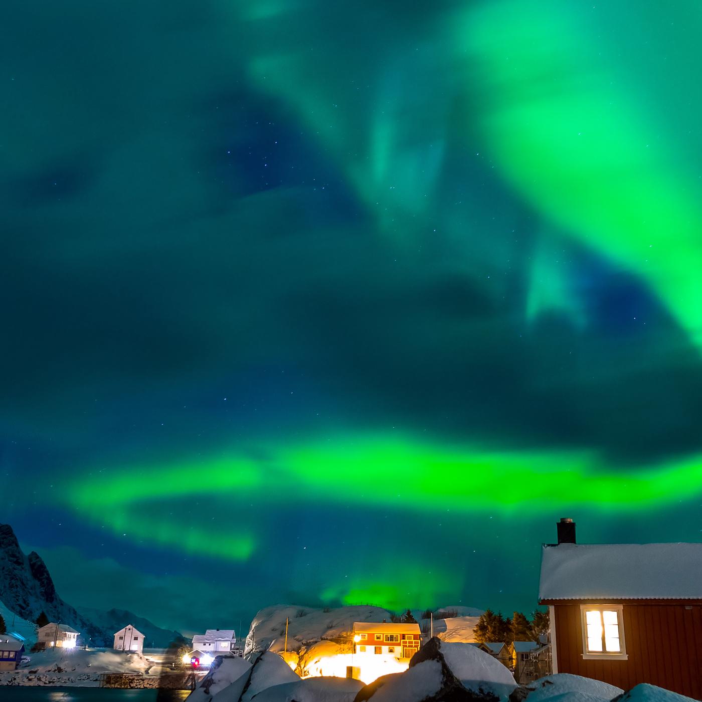 Grüne Polarlichter über einem Dorf in Skandinavien. 
