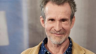 Porträtfoto eines Mannes mit graumeliertem Bart und Stoppelfrisur.