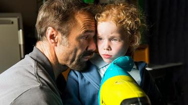 Ein Mann umarmt tröstend seine kleine Tochter