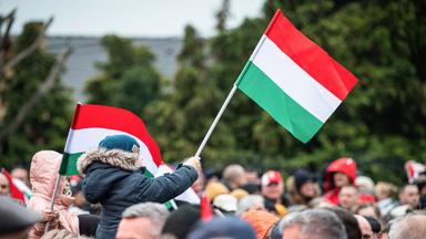 Kind hält mit ungarische Fahne in Menschenmenge 