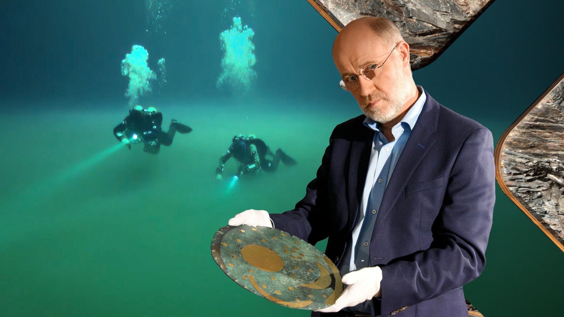 Harald Lesch steht im Vordergrund, in seinen Händen hält er die Himmelscheibe von Nebra. Im Hintergrund zwei Taucher unter Wasser, die mit Taschenlampen den Meeresgrund absuchen.