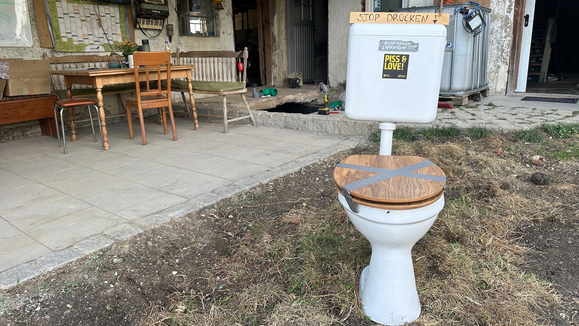 Eine ausrangierte Toilette vor einem altem Hof in Aitrang im Allgäu.
