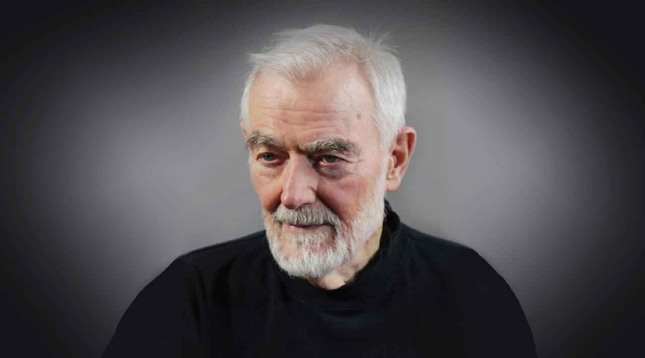 Porträtaufnahme von Peter Nestler mit kurzen, weißen Haaren und Bart sowie schwarzem Hemd.