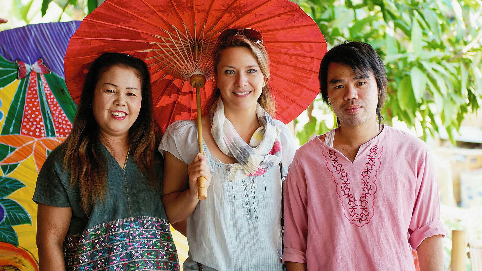 Moderatorin Wasiliki Goutziomitros (M.) mit Arbeitenden einer Schirmfabrik in Chiang Mai