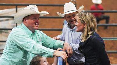 Zwei Männer mit Cowboyhüten und Barbara Lüthi unterhalten sich an einem Zaun, im Vordergrund ein Kind.