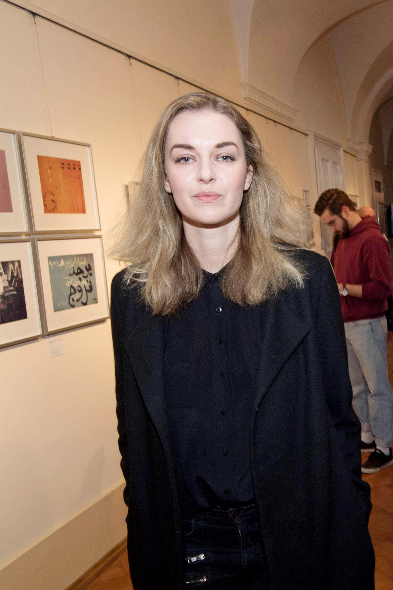 Eine junge Frau mit langen blonden Haaren schaut in die Kamera.