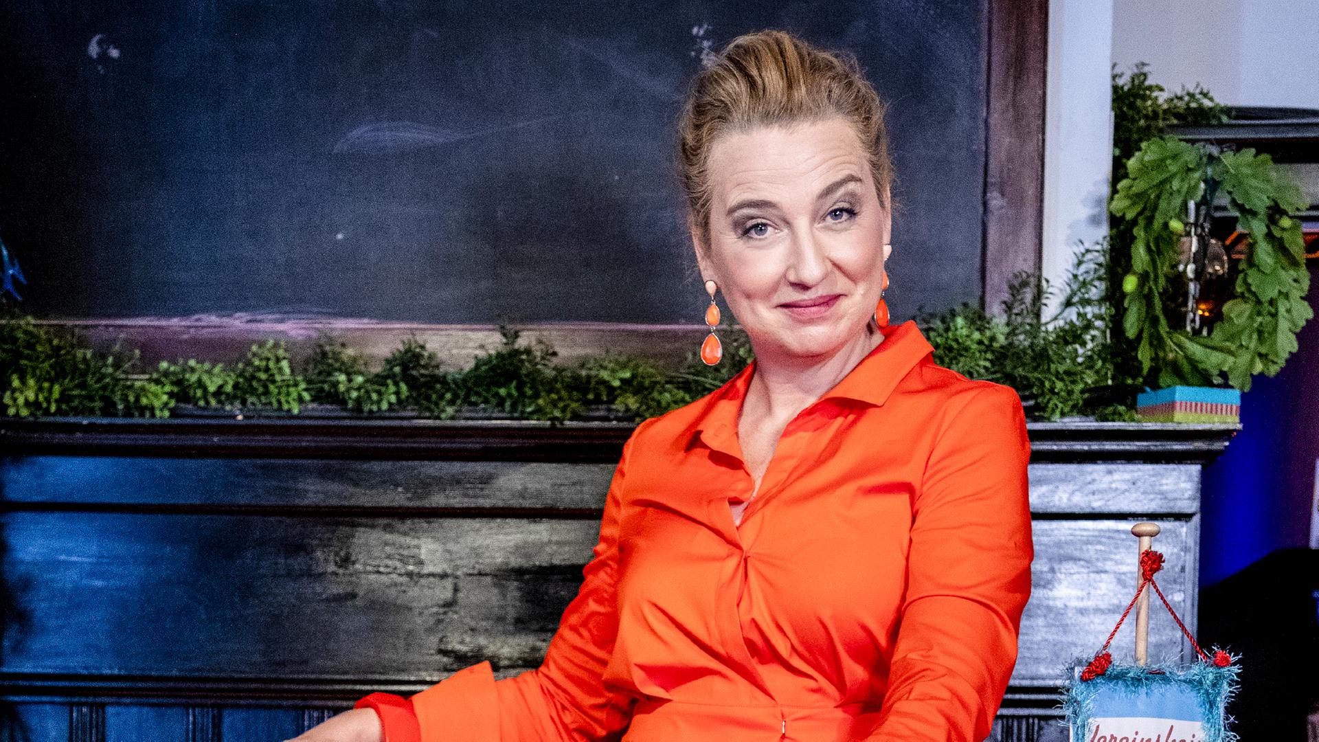 Frau sitzt auf Bank aus der ein Männerkopf schaut.