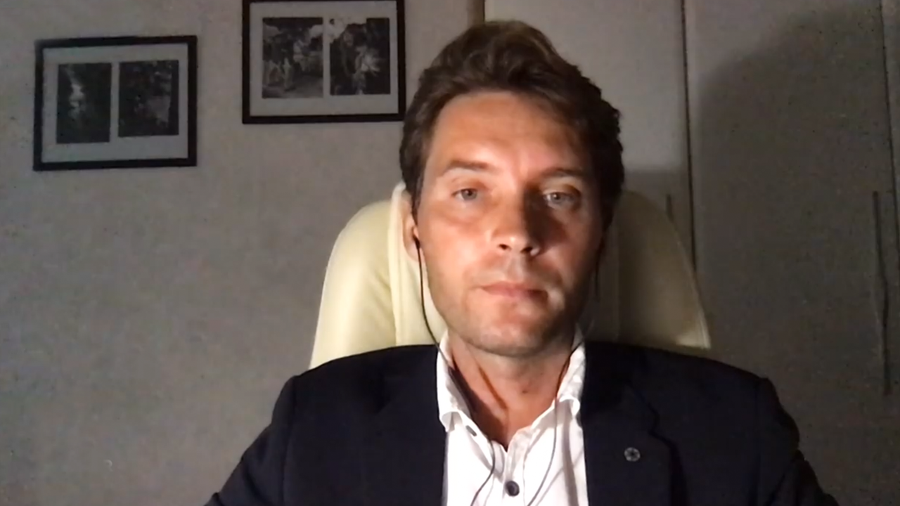 Mann sitzt in einem Sessel und trägt ein Headset.