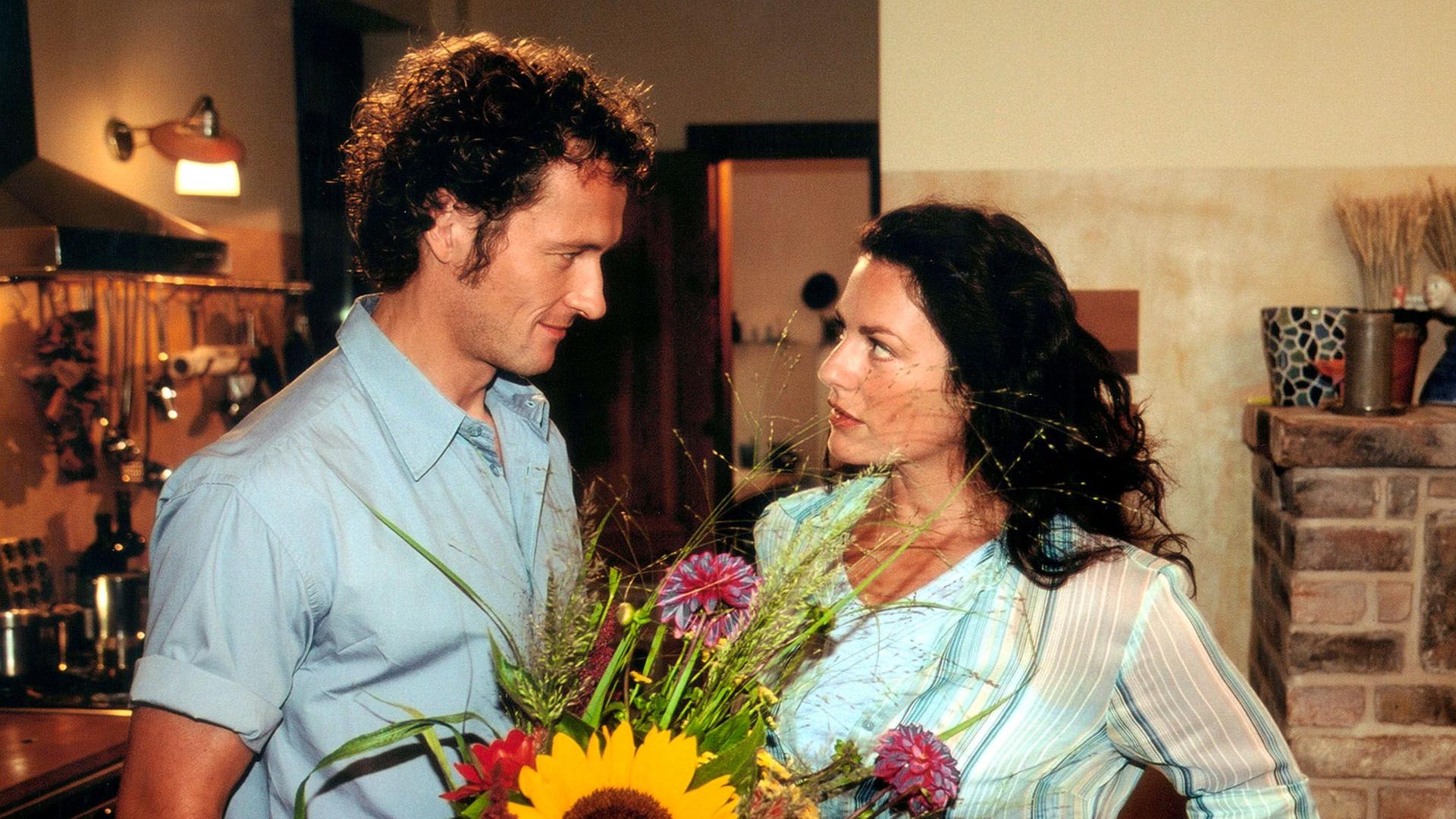 Ein Mann mit Blumenstrauß und eine Frau.