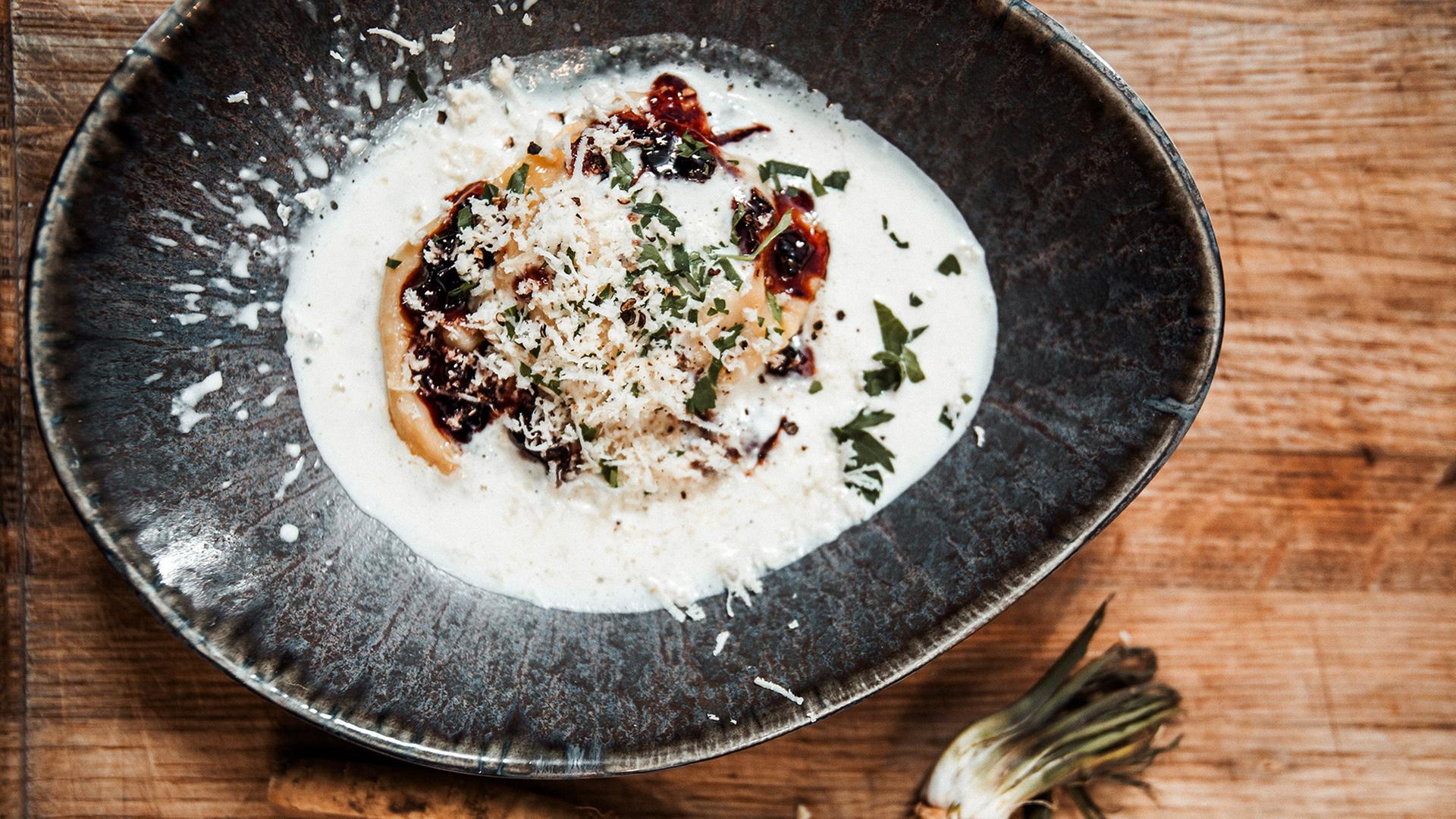 Ein Teller mit gefüllten Nudeln auf Krenschaum.