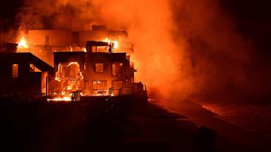 Ein Gebäude brennt bei Nacht lichterloh.