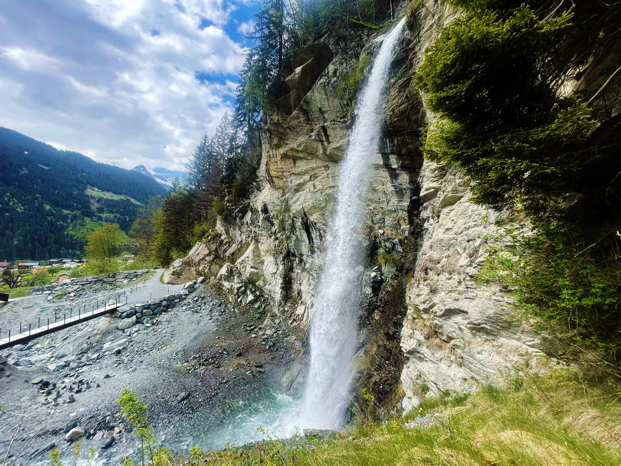 Vor blauem Himmel an einem Steilhang ein beeindruckender Wasserfall
