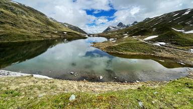 Ein See zwischne Bergen und blauem Himmel