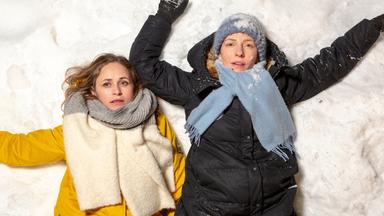 Sanne Johnen (Inez Bjørg David, l.) und ihre Schwester Annika Hombach (Katharina Schüttler) liegen erschöpft im Schnee