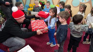 Eine Gruppe an Kindern erhält Geschenke.