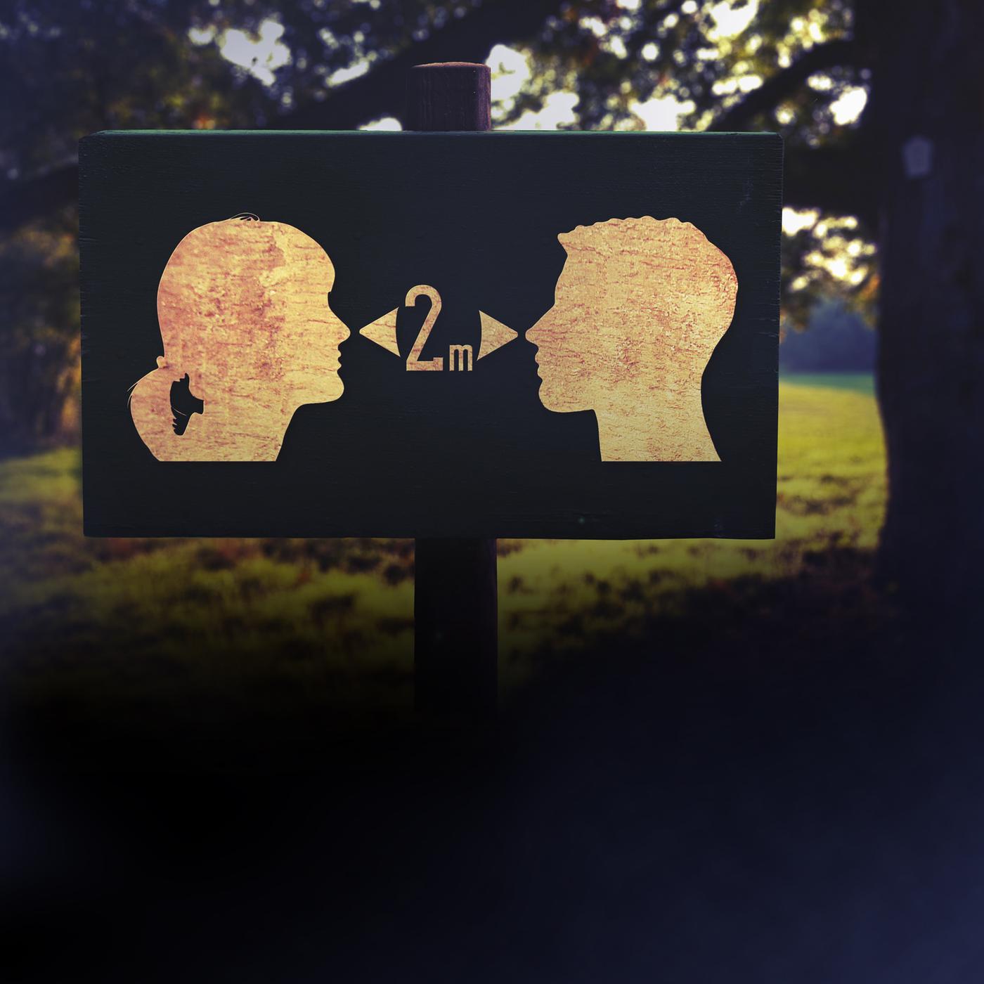 Auf einem Schild sind zwei Gesichter als Piktogramm dargestellt, die ein Pfeil mit der Aufschrift 2 Meter trennt