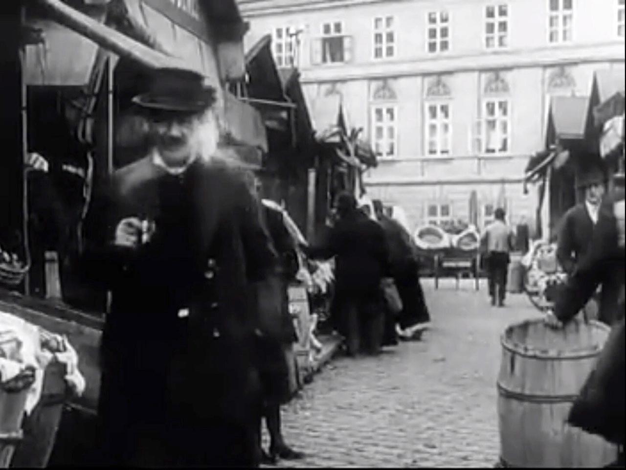 Historische Aufnahme des Naschmarktes während des Ersten Weltkriegs, belebt mit Händlern und Besuchern.