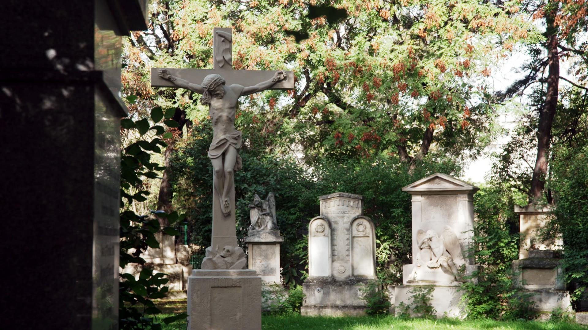 Alte Gräber zwischen Bäumen auf einem Friedhof