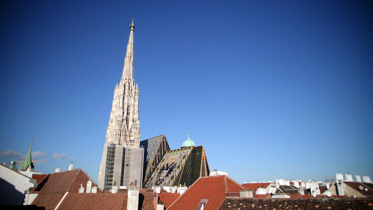 Der Dom ragt in den tiefblauen Himmel im Meer von Häuserdächern.