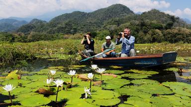 "Wildes Zentralamerika - Im Dschungel von Honduras": Drei Menschen sitzen in einem Boot auf einem See mit Seerosen.
