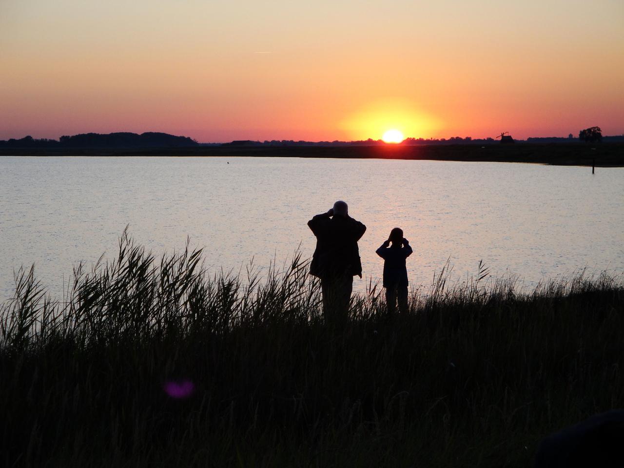 Helmut Pechlaner mit seinem Enkel Simon am Neusiedler See im Sonnenuntergang