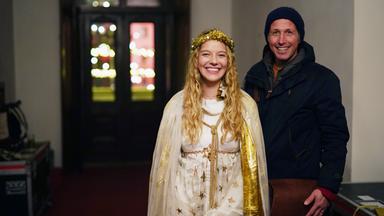 Ein Mann steht neben einer jungen Frau, die als Christkind verkleidet ist.