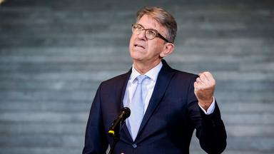 Mann steht am Mikrofon und ballt die Faust