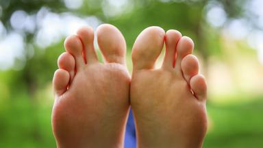 Die Welt von unten betrachtet – zwei Füße, die in ihrer natürlichen Form Geschichten erzählen.