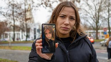 Eine Frau hält ein Handy in die Kamera.