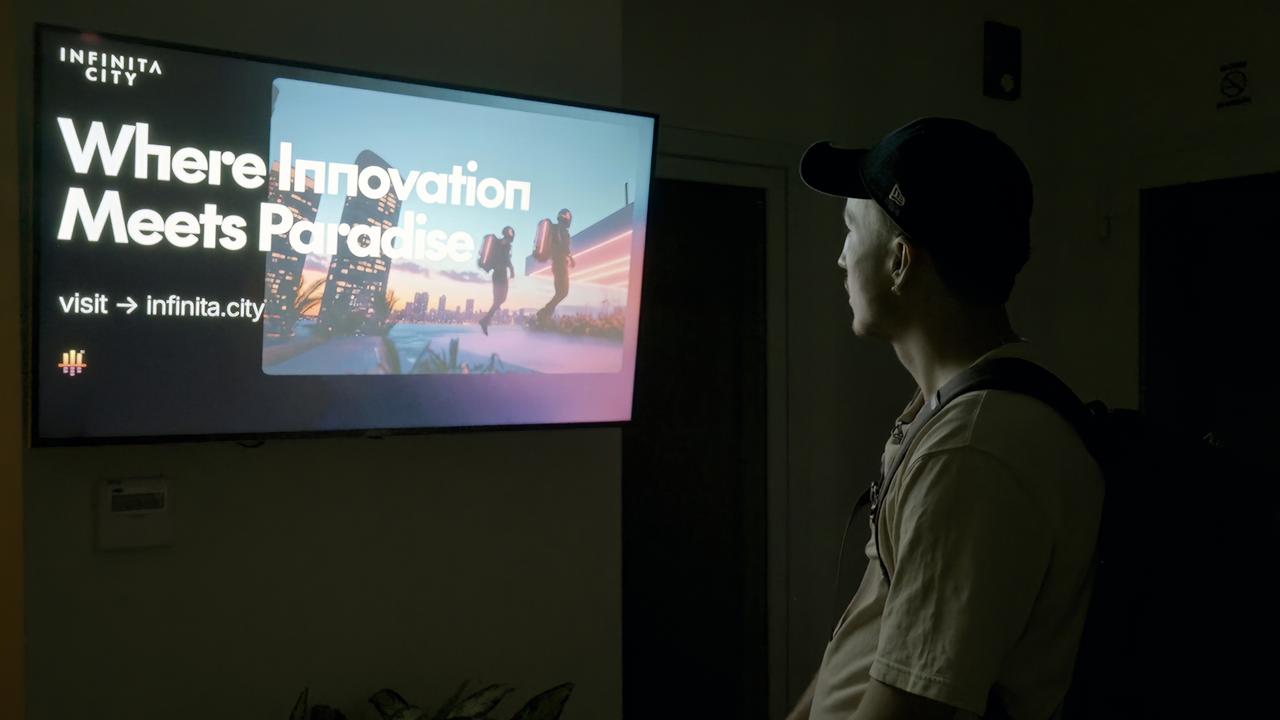Reporter Lukas Wiehler vom Y-Kollektiv betrachtet eine Werbeanzeige für die Privatstadt Próspera, die unter dem Motto „Where Innovation Meets Paradise“ um Bewohner wirbt.
