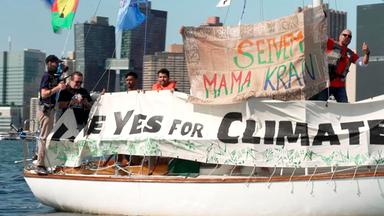 Ein Segelboot mit Fahnen und Protestflaggen.