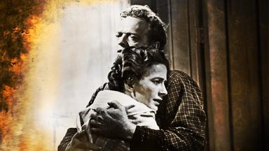 Alice Evans (Leora Dana), mit flehendem Gesichtsausdruck, und Dan Evans (Van Heflin) umarmen sich.