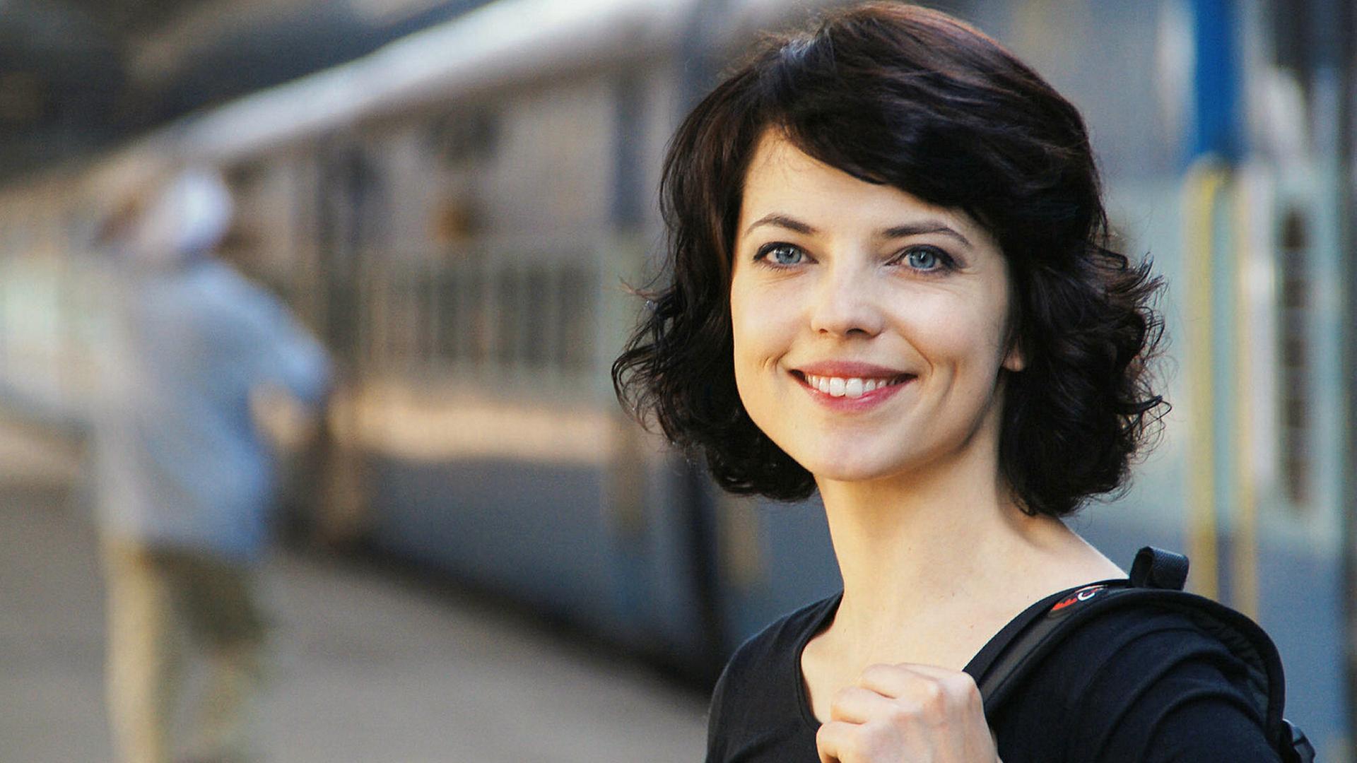 Junge Frau an einem Bahnsteig