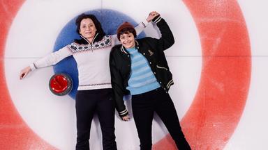 Zwei Frauen liegen Arm in Arm auf einer Eisfläche.