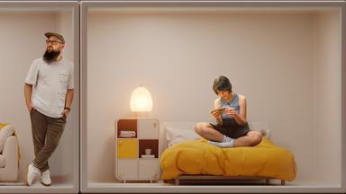 Zwei junge Menschen befinden sich in einem Zimmer, jeder für sich. Die junge Frau starrt auf ihr Smartphone.