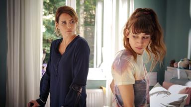 Konstanze (Anja Kling) und Jacqueline (Carol Schuler) stehen in ihrem Zimmer in der Reha-Klinik. Konstanze ist auf Krücken gestützt und sieht Jacqueline böse an.
