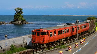 Ein Zug auf Schienen an einer Bucht.